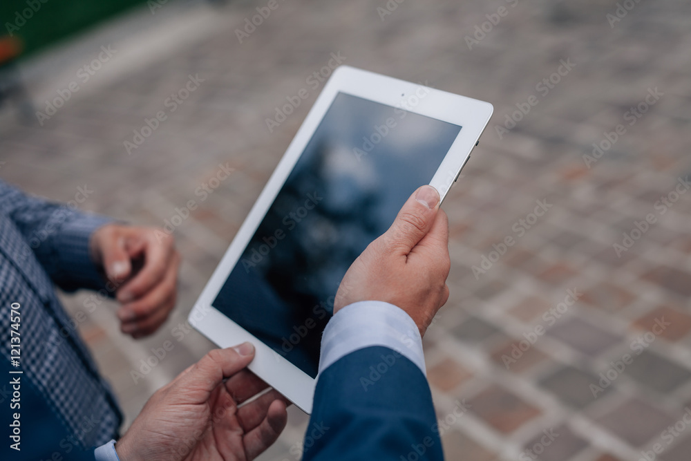 Two elegant men standing with tablet pc. Close up.

