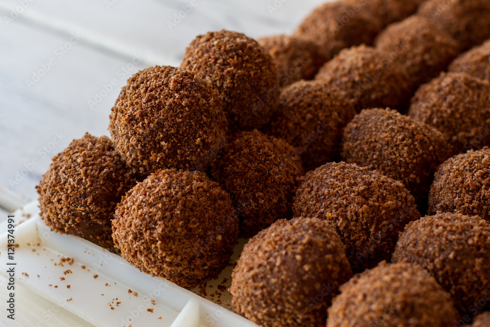 Brown ball shaped sweets. Rows of candies. Dessert from russian cuisine. Crumbled biscuits and butter. Brown ball shaped sweets. Rows of candies. Dessert from russian cuisine. Crumbled biscuits and butter.