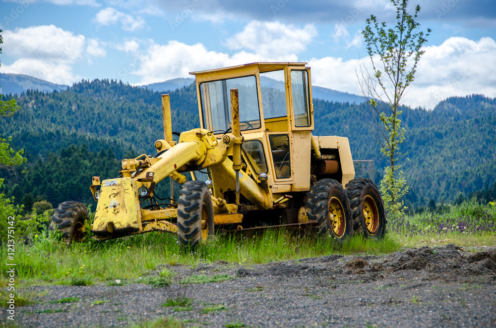 Old grader on mountainous road construction Old grader on mountainous road construction