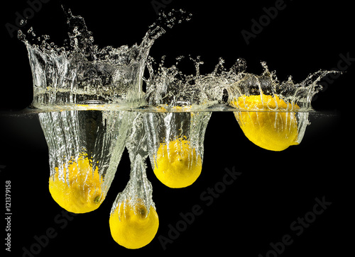 Group of fresh fruits falling in water with splash on black background