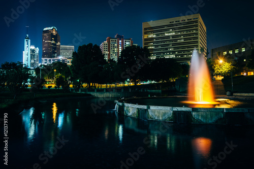 The Uptown skyline and a fountain at Marshall Park at night, in