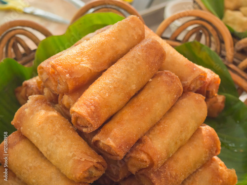 Closeup of Chinese style fried spring rolls on green banana leaf