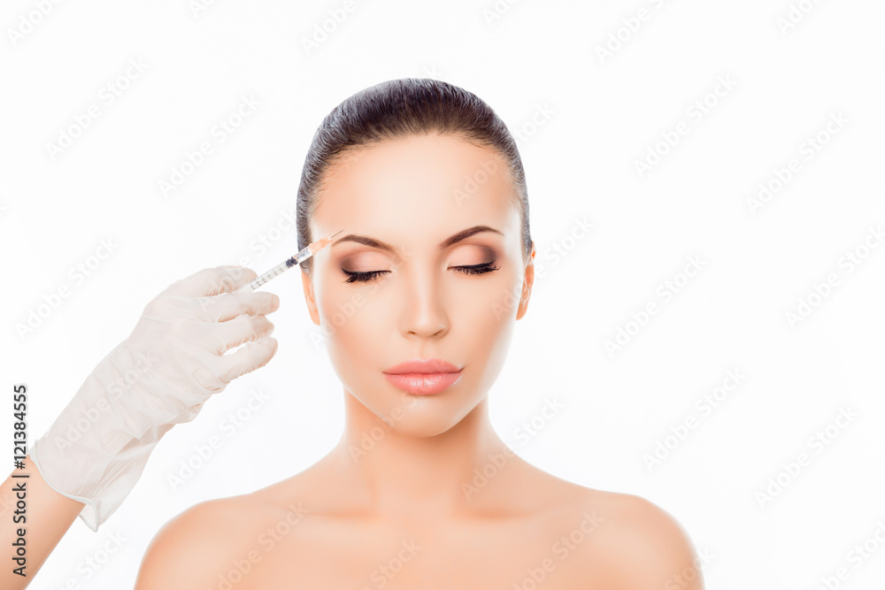 Doctor's hands making cosmetic injection in woman's face