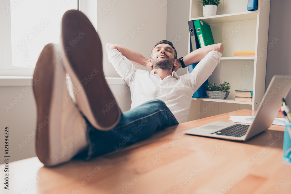 Relaxed happy man sleeping and holding legs on table Relaxed happy man sleeping and holding legs on table