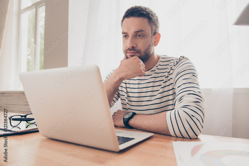 portrait of  serious man looking  at laptop