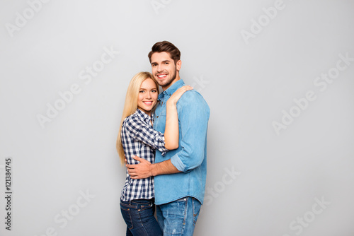 Young couple in love embracing isolated on gray background