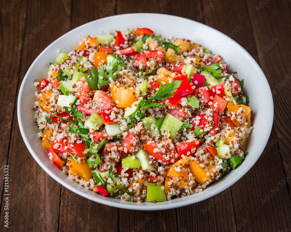 Fresh healthy salad with quinoa, colorful tomatoes, sweet pepper, cucumber and parsley on wooden background close up. Food and health. Superfood. Fresh healthy salad with quinoa, colorful tomatoes, sweet pepper, cucumber and parsley on wooden background close up. Food and health. Superfood.