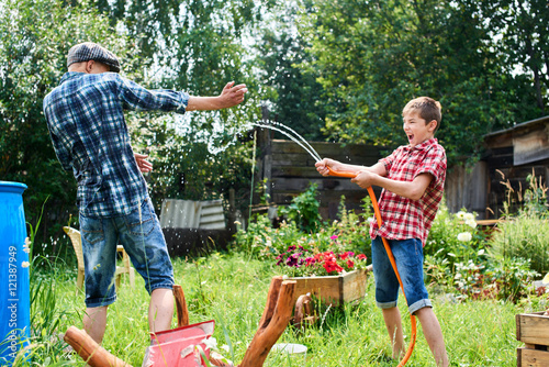 Brothers having fun splash each other with water in the village