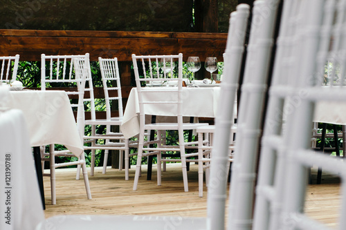 Wedding event. Chiavari chairs on the covered wooden deck. photo