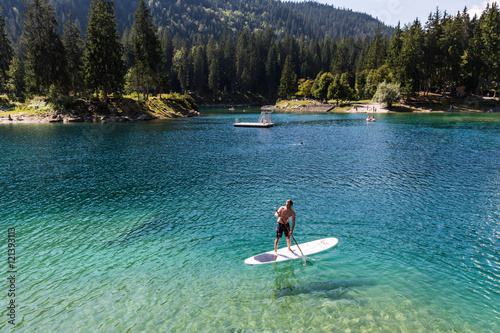 Man on a paddleboard at Caumasee, Switzerland photo