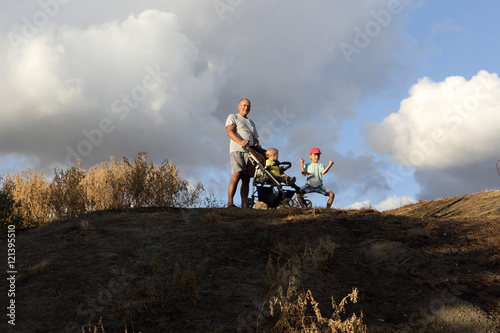 Foto Grandfather with grandsons on hill