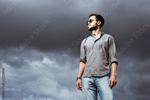 Fashion man posing on the sky bacdrop