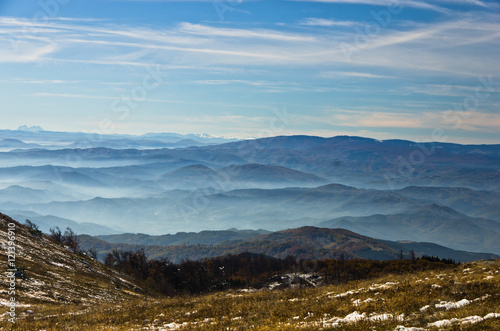 Rolling hills and mountains at autumn sunny day with fog, view from Zeljin mountain, Serbia