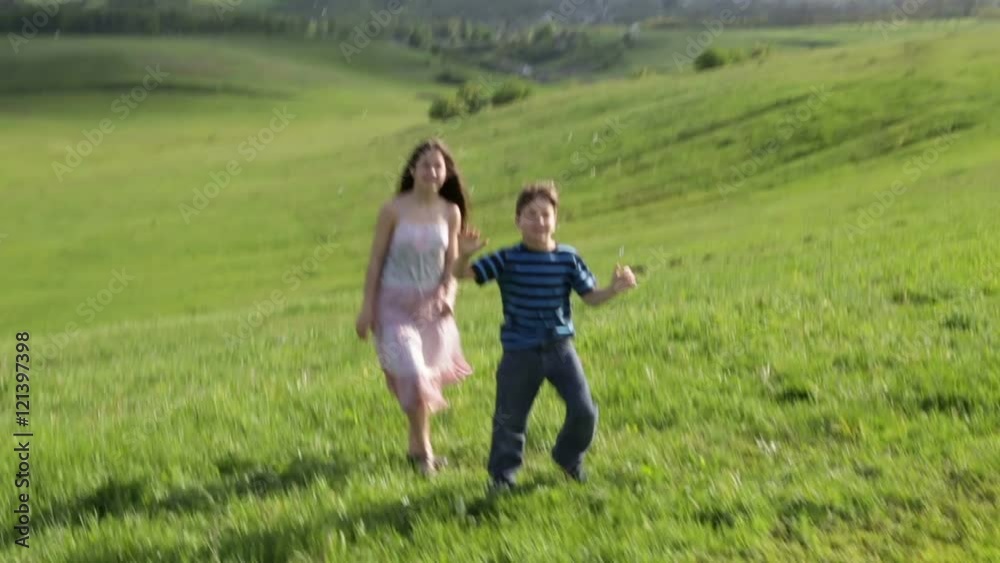Two kids catch the soap bubbles on the hill Two kids catch the soap bubbles on the hill