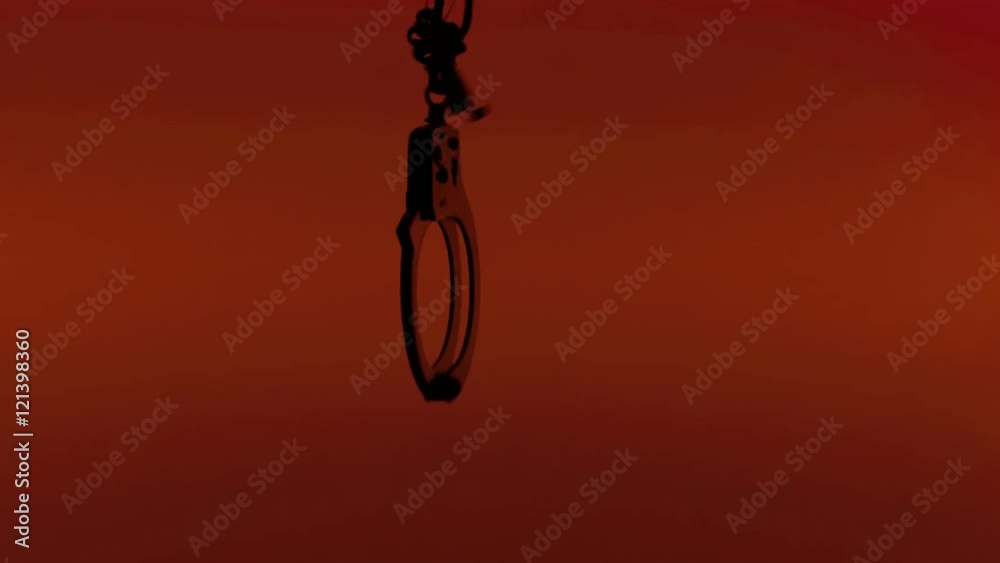 Dancing handcuffs. Close-up silhouette symbolic shot on red background: law enforcement, crime, punishment, erotica, bondage.
Dancing handcuffs. Close-up silhouette symbolic shot on red background: law enforcement, crime, punishment, erotica, bondage.