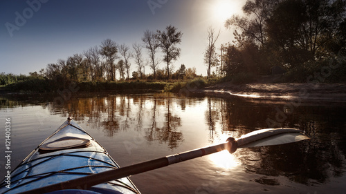 Blue rayak on river, sunset scene. Instagram filter toning. photo