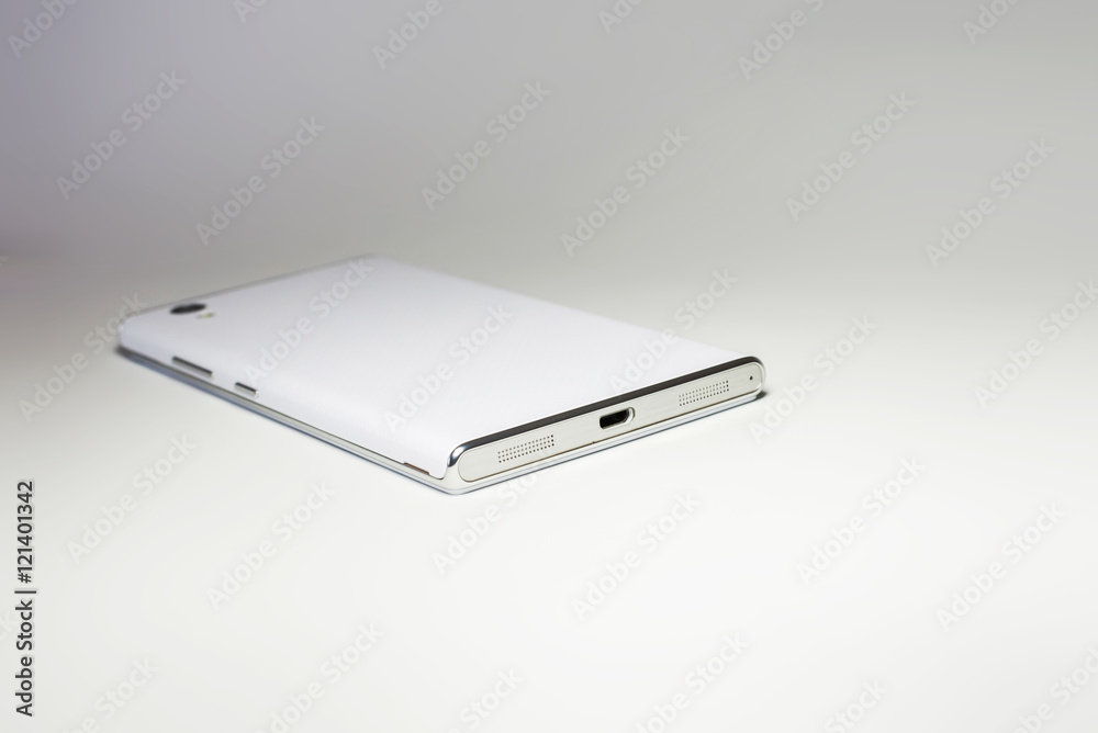 White modern smartphone with blank back lies on the surface, isolated on white background. Elements. White modern smartphone with blank back lies on the surface, isolated on white background. Elements.
