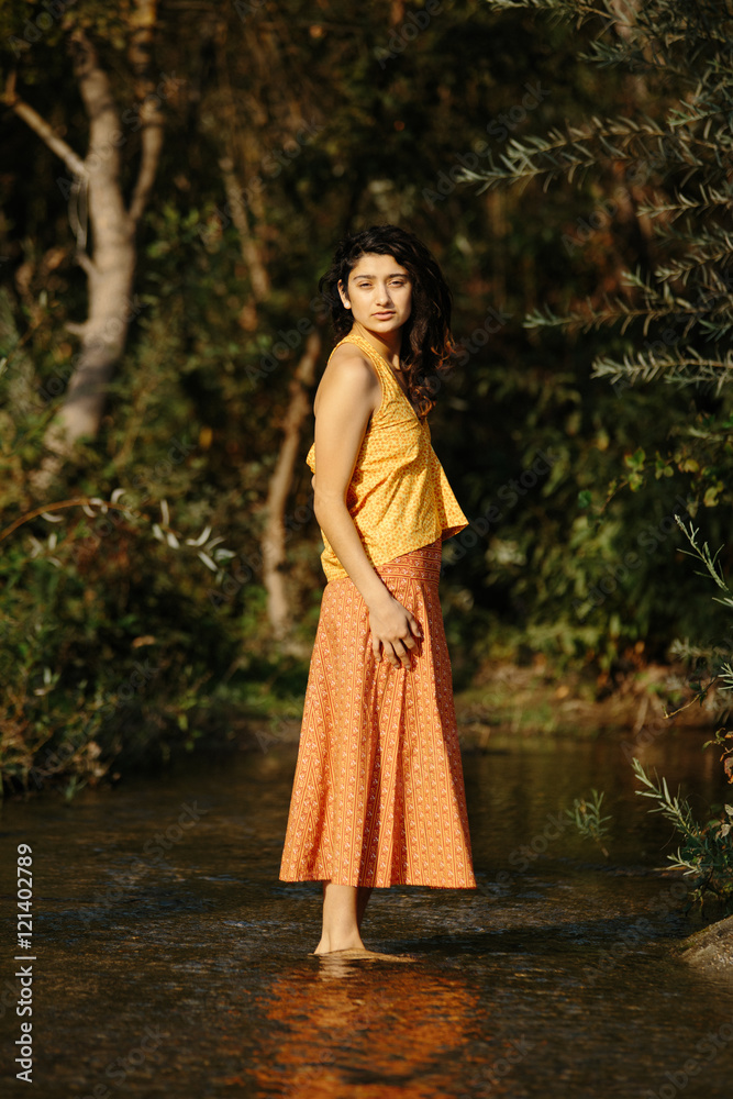 Young Hispanic Girl in Handmade Clothing in River in Nature