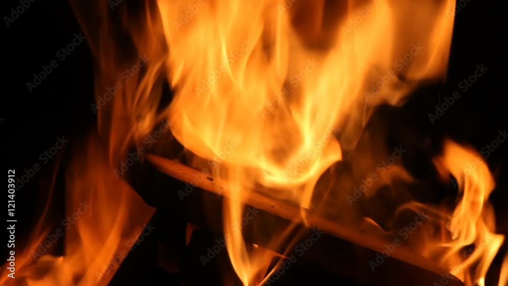 Closeup of a large fire. Wooden planks to the fire. The fire is lit in the night. Closeup of a large fire. Wooden planks to the fire. The fire is lit in the night.
