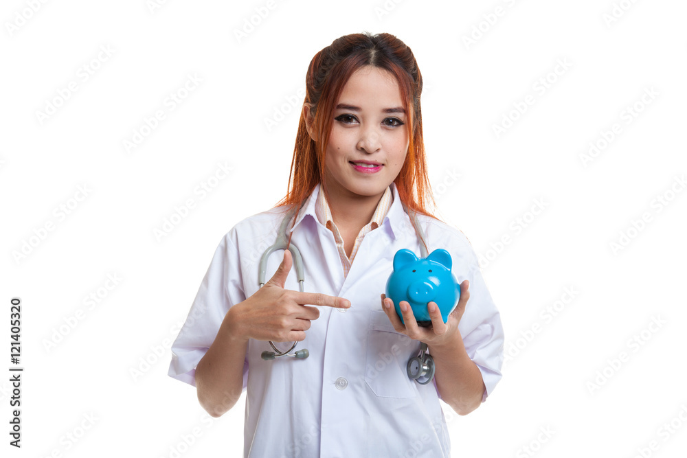 Young Asian female doctor point to a pig bank coin. Young Asian female doctor point to a pig bank coin.