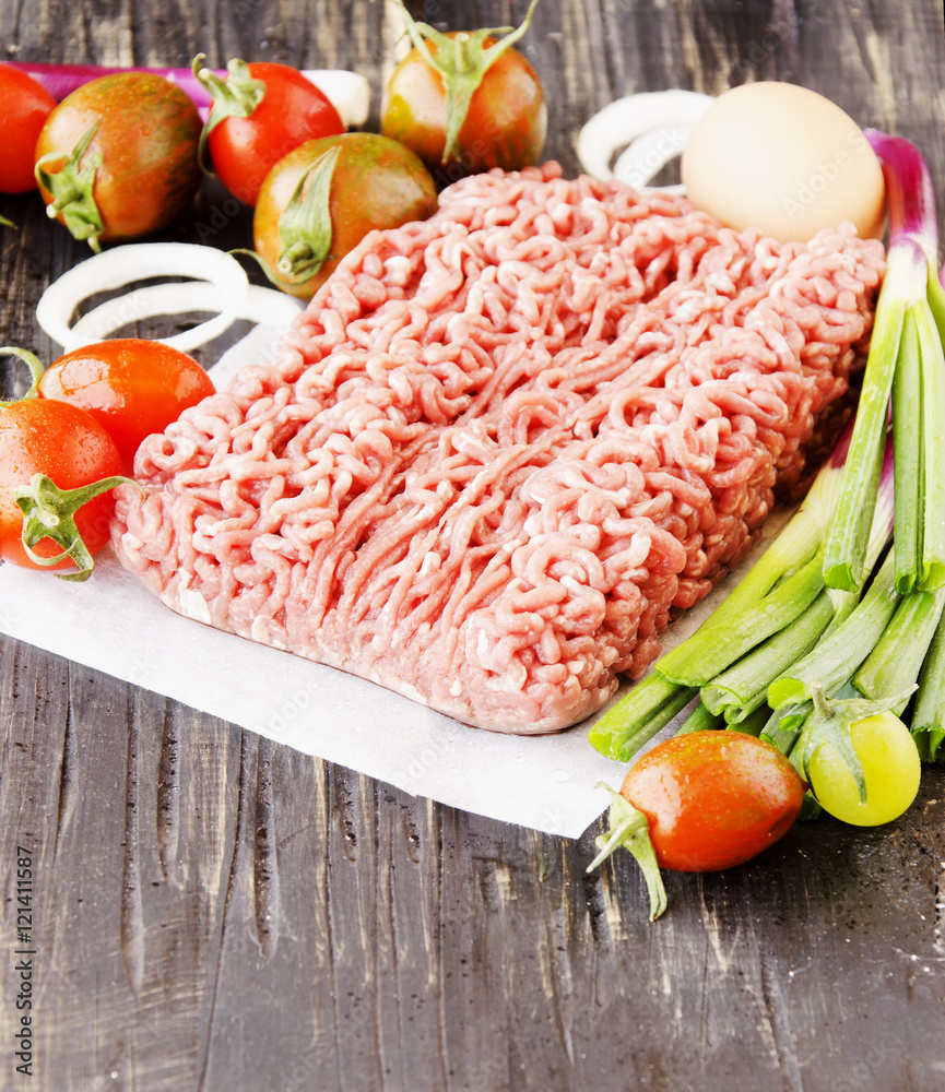 raw minced meat, vegetables with salt and spices, selective focus raw minced meat, vegetables with salt and spices, selective focus