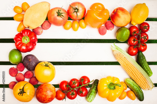 Juicy fruits and vegetables in a circle at the white boards background. Free space for text in the center. Top view.