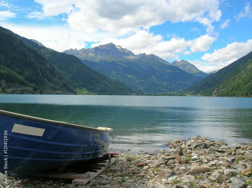 lake in the Swiss Alps with small boat in foreground