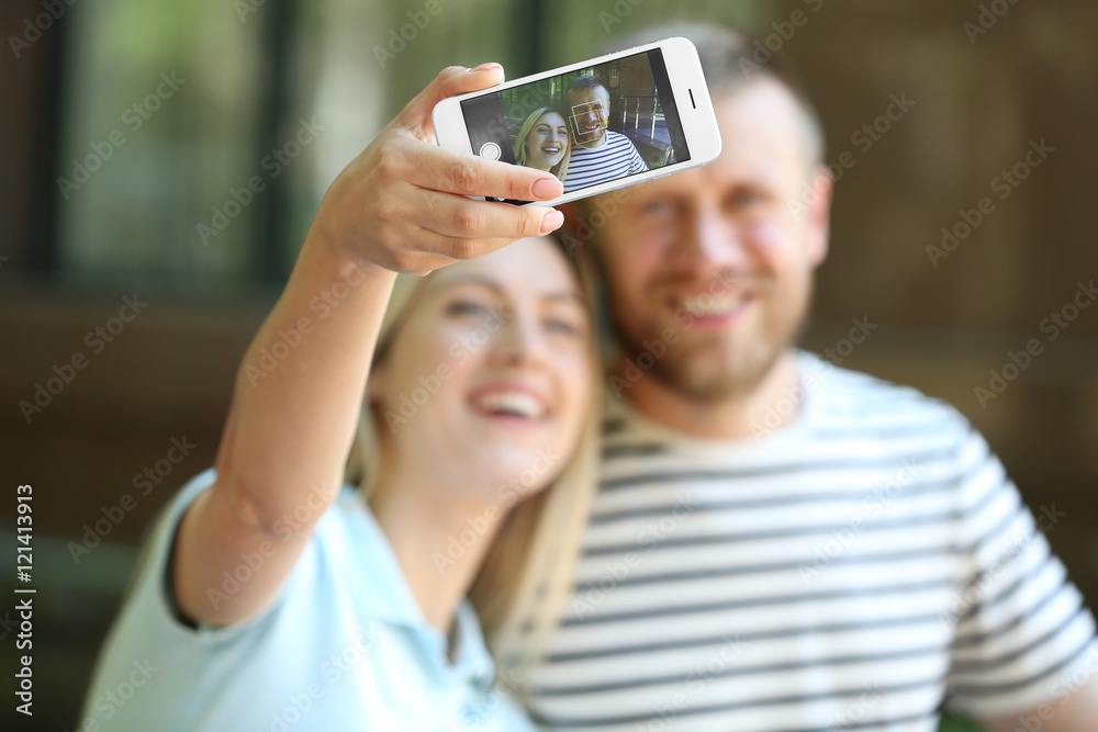 Happy couple taking selfie on the street