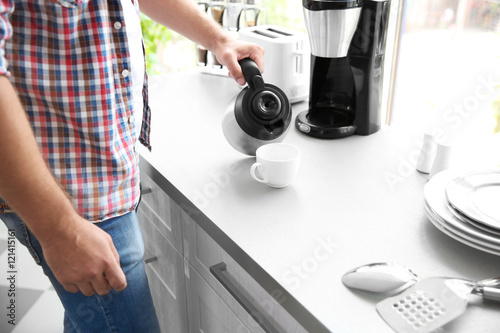 Man making morning coffee in kitchen