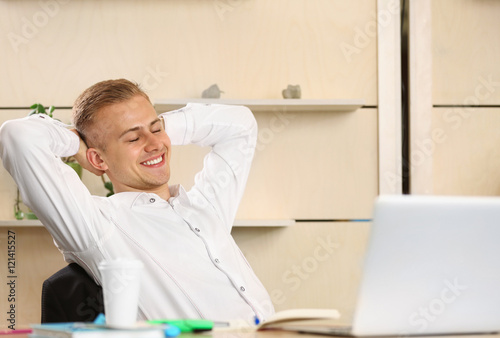 Happy man with laptop in of...