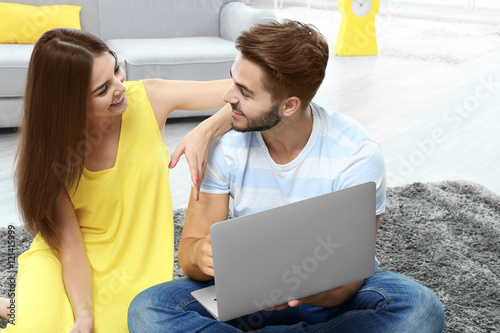 Beautiful young couple usin...