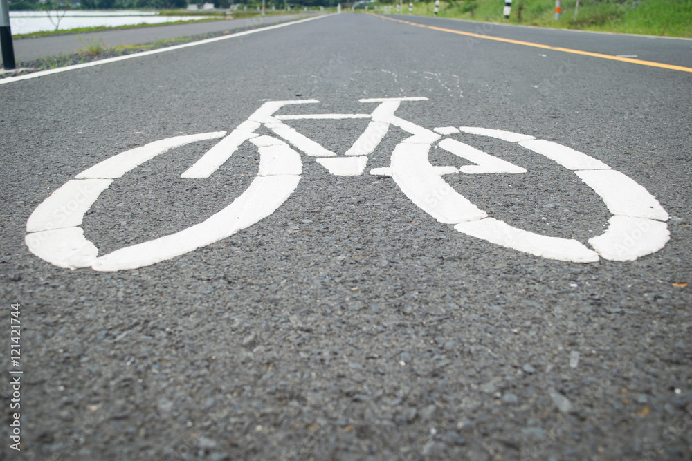 Obraz premium Cycle path lane sign in a wet urban street.