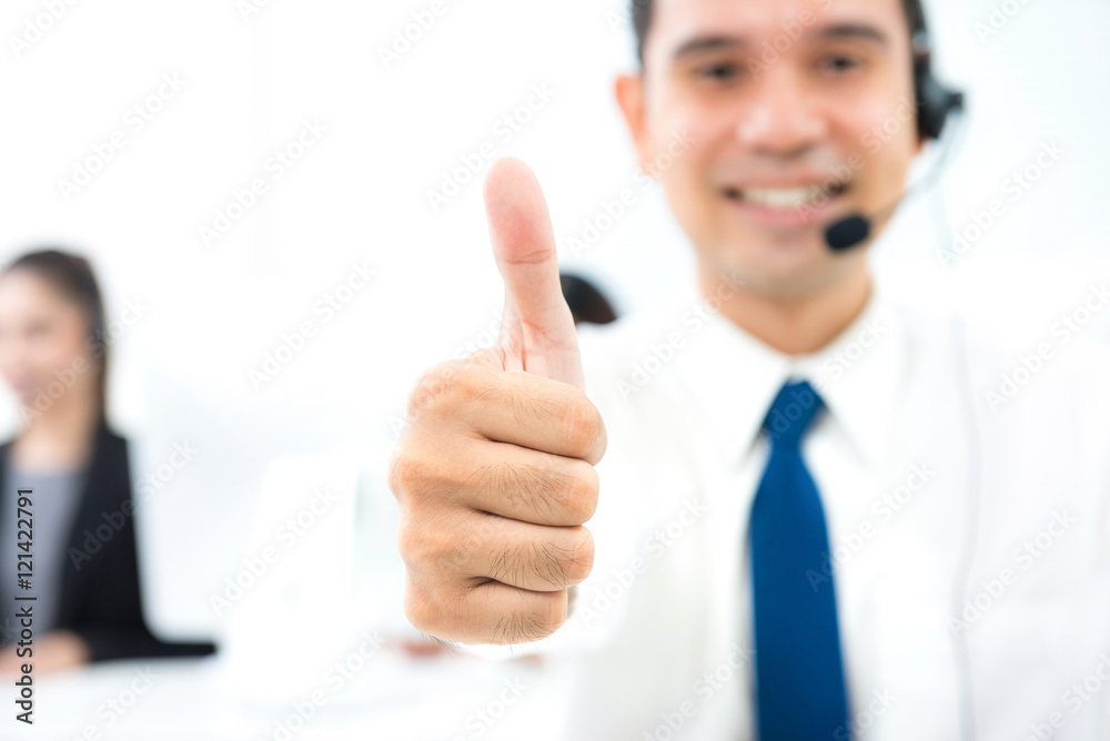 Male call center (or telemarketer) staff giving thumbs up Male call center (or telemarketer) staff giving thumbs up