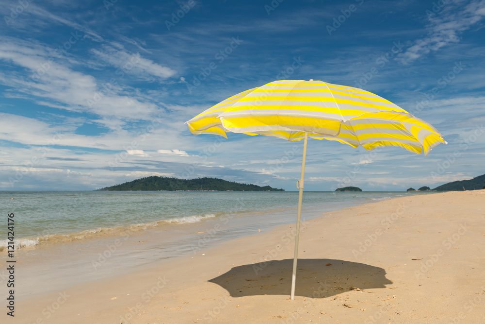 white and yellow striped beach umbrella on sunny day