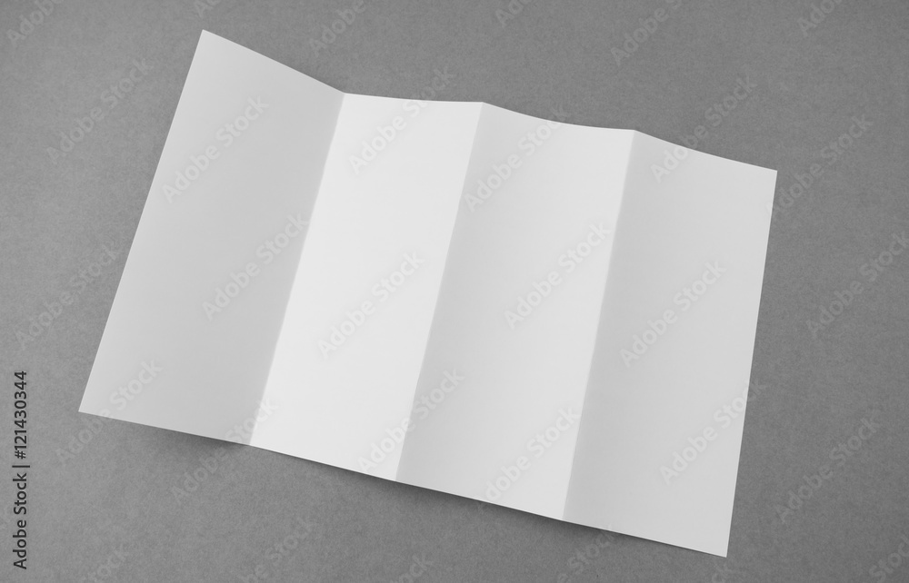 Four - fold white template paper on gray  background .