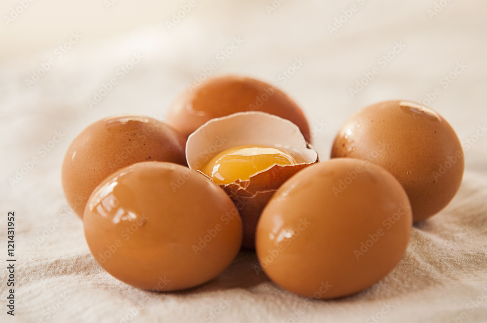With brown eggs on a white background. One egg is broken. With brown eggs on a white background. One egg is broken.