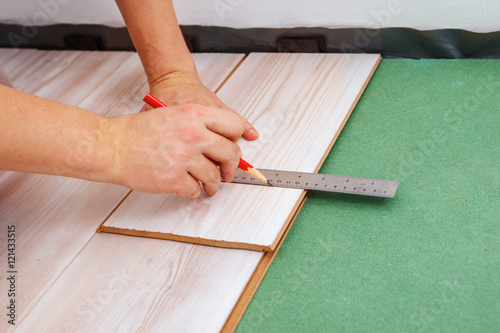 Contractor measuring a laminate piece © 2xSamara.com