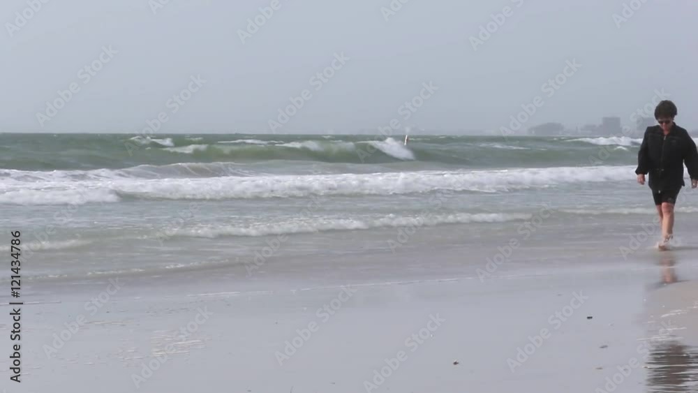 Woman walking through surf looking for sea shells. Woman walking through surf looking for sea shells.