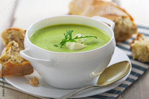 Broccoli cream soup with bread on a table. Classic European food. Close-up shot.
