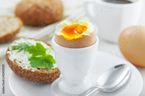 Perfect soft boiled egg, bread and butter with coffee for breakfast. Traditional healthy food.