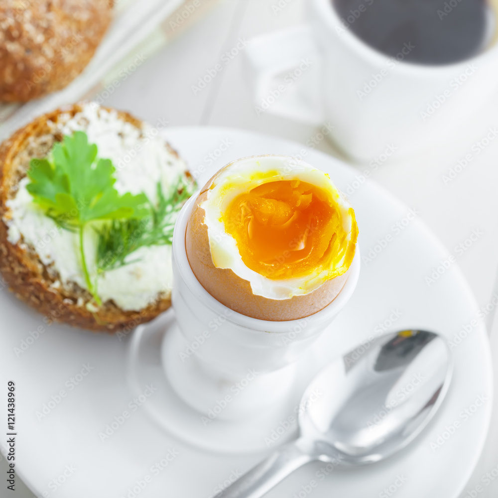 Fototapeta premium Perfect soft boiled egg, bread and butter with coffee for breakfast. Traditional healthy food. Top view.
