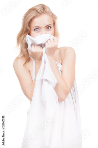 Beautiful naked girl covered with a white cloth on a white background.