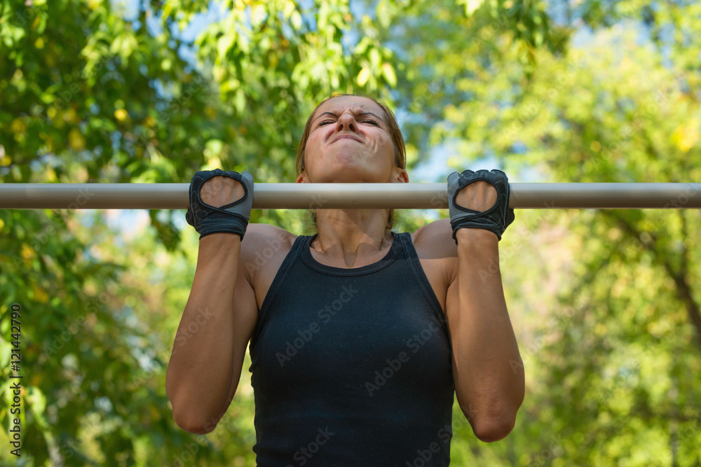 Fototapeta premium Chin ups on chin up bar in the park