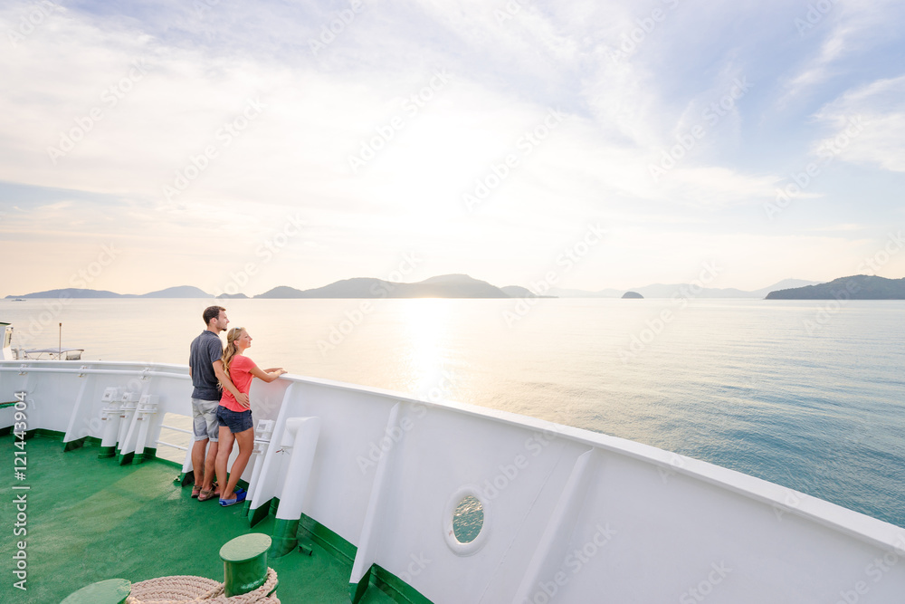 Fototapeta premium Romantic vacation. Young loving couple enjoying sunset on cruise ship deck. Sailing the sea.