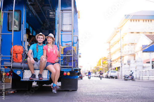 Backpacker concept. Traveling Asia. Young handsome man with his girlfriend on traditional thai bus. photo