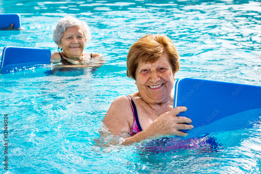 Senior women doing aqua exercise with kick boards. StockFoto Adobe Stock