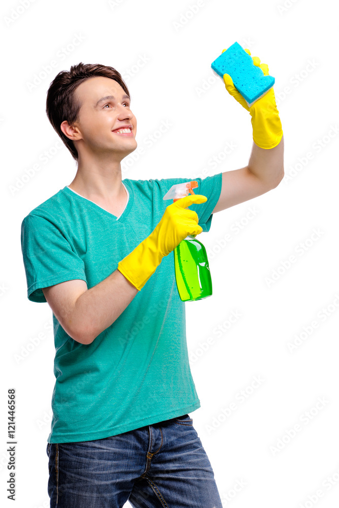 Housekeeping concept. Studio portrait of handsome young man in gloves cleaning glass with wisp and sprayer. Isolated on white. Housekeeping concept. Studio portrait of handsome young man in gloves cleaning glass with wisp and sprayer. Isolated on white.