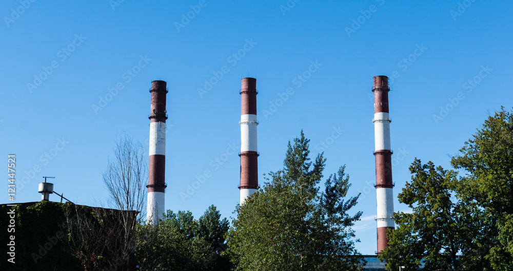 Red and white classic factory pipe in the blue sky.
Red and white classic factory pipe in the blue sky.