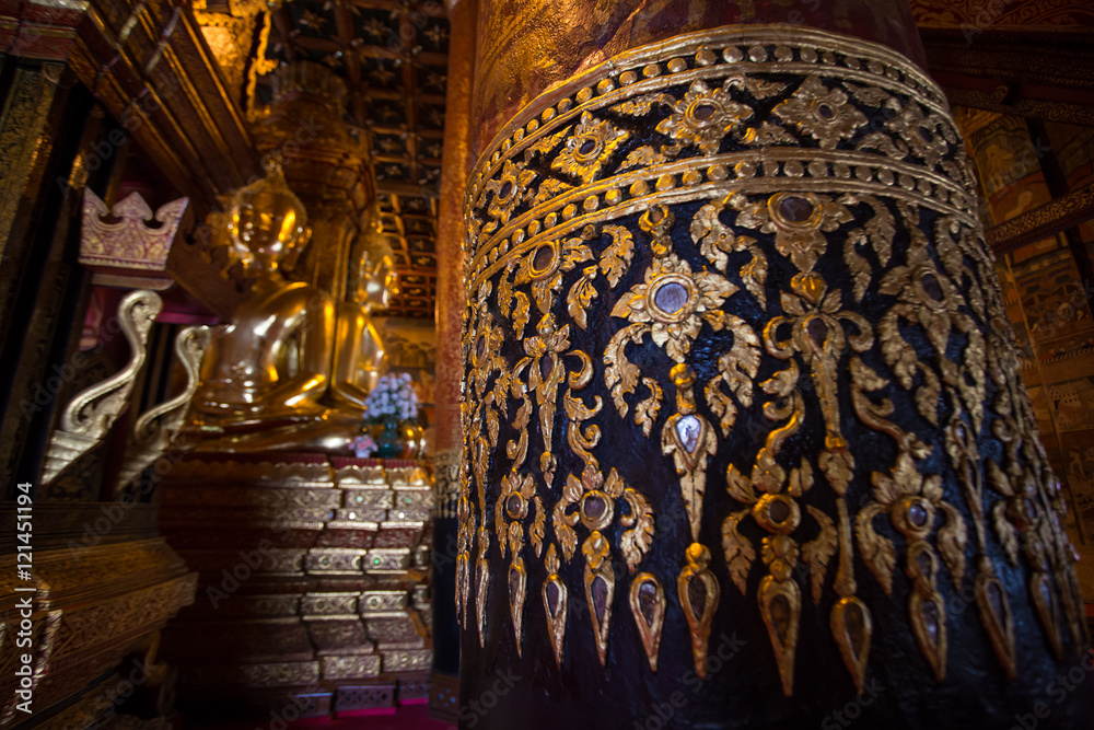 Thai style golden pattern showing texture on a pole in main hall in Phumin Temple, Nan, Thailand
