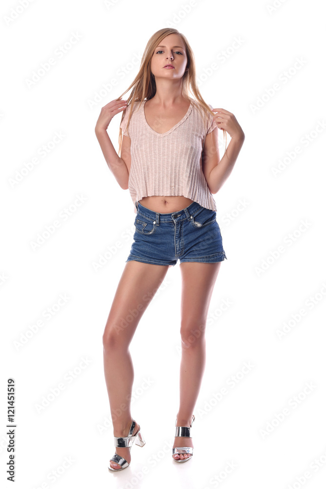 Young pretty blonde woman posing in shorts on white background in a studio. Fashion spring summer photo, catalog collection. Young pretty blonde woman posing in shorts on white background in a studio. Fashion spring summer photo, catalog collection.